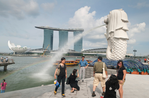 Singapore -aa June 26, 2011: Tourists taking photos of Merlion with Marina Bay Sand in background.