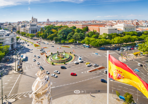 Madrid, Spain - September 14th, 2013: View of Plaza de la Cibeles with fountain of Cibeles in the center. This fountain, named after Cybele (or Ceres), Roman goddess of fertility, is seen as one of Madrid's most important symbols. Multitude of cars visible on the roundabout surrounding the fountain. On the left side Banco de EspaAa building is clearly seen.