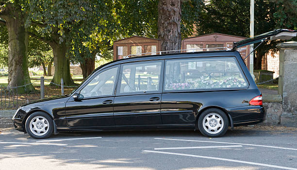sad day Pontesbury, Shropshire, UK - 25th September, 2008: Black hearse outside the church in Pontesbury during a family funeral hearse photos stock pictures, royalty-free photos & images