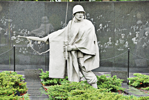 Washington DC USA - October 10, 2009: Statue of an American soldier serving in the Korean War is part of the Korean War Veterans Memorial in Washington DC. Wall in background is ectched with figures of soldiers who served in various branches of the military during the war.