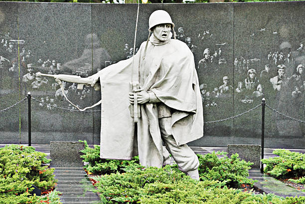 Statue at Korean War Veterans Memorial in Washington Washington DC USA - October 10, 2009: Statue of an American soldier serving in the Korean War is part of the Korean War Veterans Memorial in Washington DC. Wall in background is ectched with figures of soldiers who served in various branches of the military during the war. soldier on the wall stock pictures, royalty-free photos & images