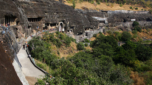 Tourists visit cave carvings at the Ajanta Caves New Delhi, India - November 15, 2012:Tourists visit cave carvings at the Ajanta Caves  in Aurangabad district of Maharashtra, India, where about 300 rock-cut Buddhist cave monuments date from the 2nd century BCE to about 480 or 650 CE. The site is a protected monument in the care of the Archaeological Survey of India, and since 1983, the Ajanta Caves have been a UNESCO World Heritage Site. ajanta caves stock pictures, royalty-free photos & images