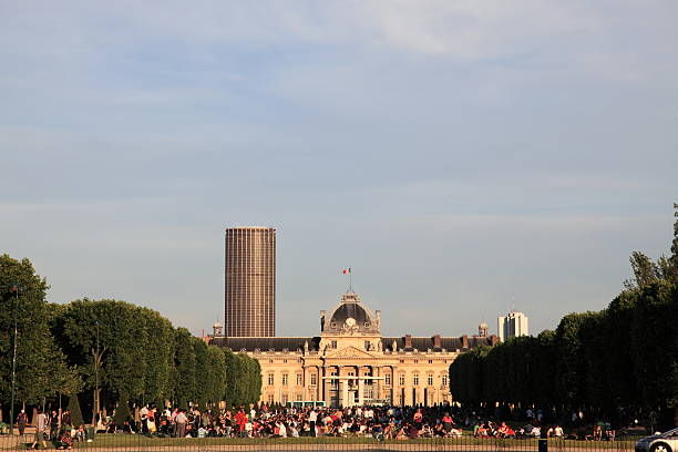 Ecole Militaire and people in Champ de Mars, Paris Paris, France - June 17, 2009: The central building of Ecole Militaire and in the background Tour Montparnasse (Montparnasse Tower) seen from the park Champ de Mars half way to the Eiffel Tower. In the park lots of tourists and local French people enjoying a lovely June evening before sunset. ecole stock pictures, royalty-free photos & images