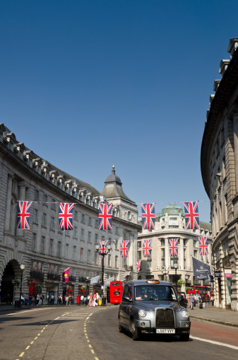 London, United Kingdom - April 23, 2011: A taxi drives down Regent Street in London. The length of the street has been decorated with festive Union Jack bunting to celebrate the Royal Wedding of Prince William and Kate Middleton. Regent Street in London's West End is one of the most popular shopping areas in the UK and attracts over 50 million visitors each year.