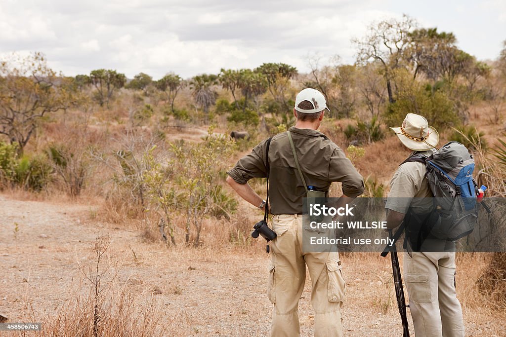 Tanzaniano safari a piedi con una guida guardare un elefante - Foto stock royalty-free di Riserva del Selous