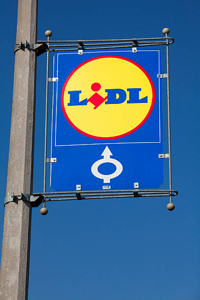 Gyor, Hungary - May 29, 2011: Sign of Lidl supermarket against blue sky. The sign is fixed on a pole, showing the direction to the store. Lidl is a German discount supermarket chain that operates over 7200 stores across Europe.
