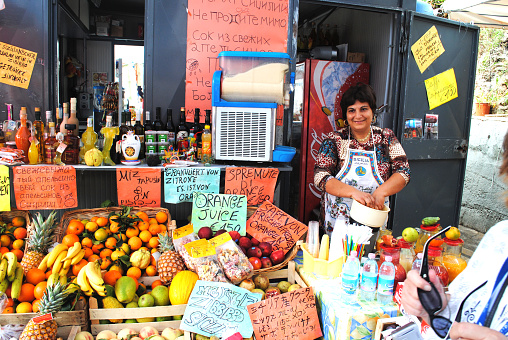 Palermo, Sicily - September 27, 2010: Middle aged woman, selling her goods (fruit) at a traditional sales stall in Palermo / Sicily.