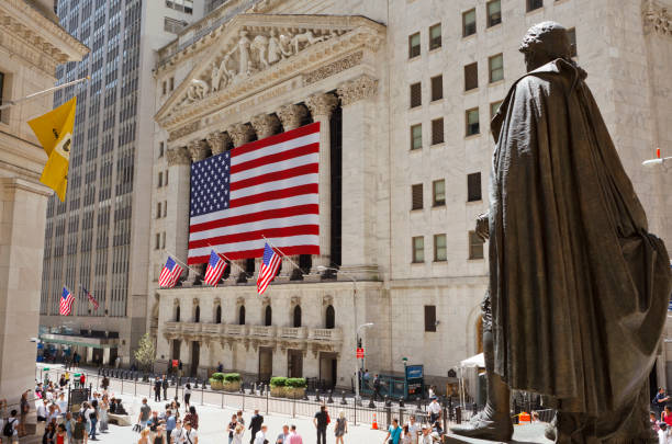 New York, New York, USA - June 2, 2011: The New York Stock Exchange as seen from the steps of Federal Hall. The back of the statue of George Washington is in the foreground. People can be seen on the street on this sunny day. Manhattan, New York City.