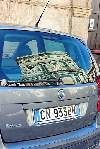 Tropea,Calabria,Italy - September 28, 2013: Facade of a historical house reflected in the rear windscreen of a Fiat Idea car, parked in a street of the old district of Tropea, a town located in the province of Vibo Valentia in Southern Italy. 
