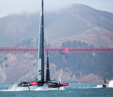 San Francisco, USA - August 17, 2013: Oracle Team USA's 72 foot America's Cup catamaran sailboat hydrofoiling on San Francisco Bay during a training run. Part of the Golden Gate Bridge in the background.