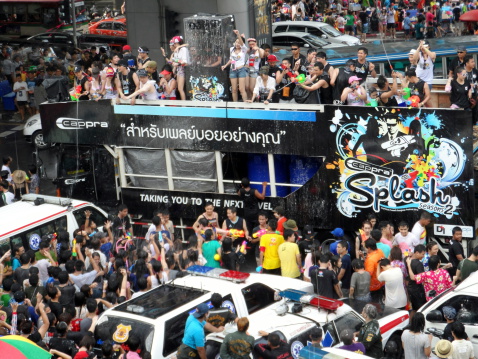 Bangkok, Thailand aa April 13, 2013: People promoting a company brand celebrate Songkran Festival (Thaiaas New Year) at Silom, Bangkok, Thailand. They dance and splash water with Thais and tourists. Many Thais and tourists celebrate Songkran Festival here. Ambulances and volunteers are prepared to help injured people. One of the main Songkran celebrations is throwing water at each other.