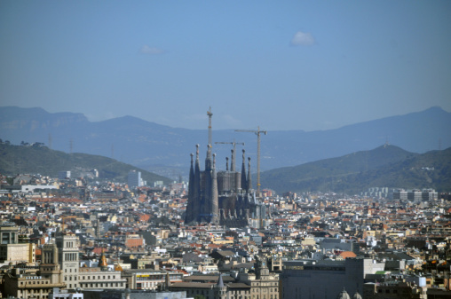 Barcelona, Spain - April 24, 2013: Afternoon in the city. Construction continues on La Sagrada Familia (a Gaudi design - in process since 1882) Zoom shot taken from Parc Montjuic.