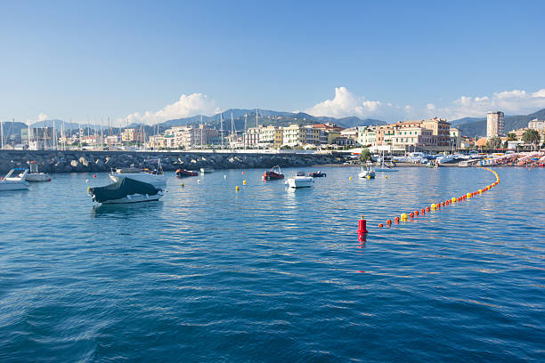 Lavagna, Italy - September 4, 2013: Small boats with visible names are moored at the harbour of Lavagna, one of the towns of the Italian Riviera. People can be seen at the water's edge in the background.