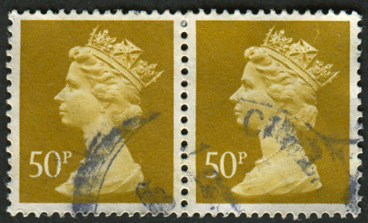 Gomel, Belarus - May 15, 2013: Postage stamp. A stamp printed in UK shows image of Elizabeth II is the constitutional monarch of 16 sovereign states known as the Commonwealth realms, in Ochre Brown, circa 1977.