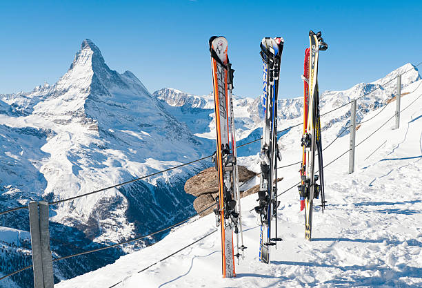 Skis and View of the Matterhorn Zermatt, Switzerland - January, 16th 2011: Skis and poles in the snow at the Swiss ski resort of Zermatt.  The famous peak of the Matterhorn (4,478m/14,692ft) is visible to the left. brightly lit winter season rock stock pictures, royalty-free photos & images