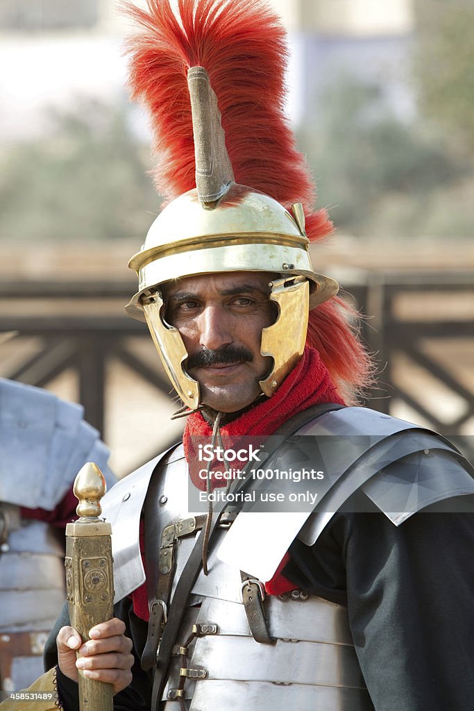 Centurion in the arena - Jerash, Jordan Jerash, Jordan - December 20, 2010: A centurion from the Legion VI Ferrata, the &quot;Ironclads&quot;, smiles as he stands with his legion, as part of a performance at a hippodrome in Jerash, situated in the north of Jordan.Jerash is known for the ruins of the Greco-Roman city of Gerasa, also referred to as Antioch on the Golden River. The Roman Army and Chariot Experience (RACE), in co-operation with the Jordan Ministry of Tourism and the Jordan Tourism Board, have introduced a show featuring Roman Army warfare techniques, gladiators and Roman chariots races, to bring to life historical events that took place in the ancient arena. Acting - Performance Stock Photo