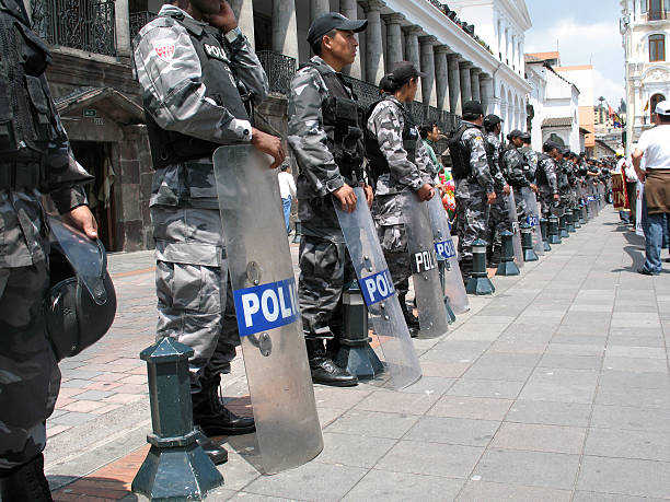 Row of South American riot police confronting demonstrators Quito, Ecuador - November 20, 2008: Row of South American riot police confronting teachers and lecturers demonstrating against education cuts in Quito's main square. The square outside the Presidential Place is called &amp;quot;La Plaza de la Independencia&amp;quot; riot police stock pictures, royalty-free photos & images