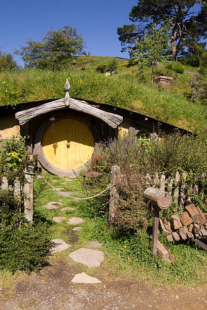 Hobbiton - Hobbit Hole Matamata, New Zealand - 7 January 2013: A hobbit hole in The Shire at Hobbiton. Previously used in the filming of the Lord of the Rings and The Hobbit series of movies, it is part of a movie set that has been retained for guided tours. This particular hobbit hole was the residence of the character Sam. matamata new zealand stock pictures, royalty-free photos & images