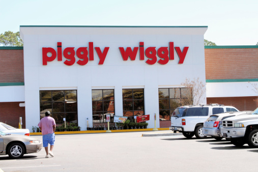 Johns Island, SC, USA - March 13, 2011:  A man walks towards a Piggly Wiggly Supermarket from the store parking lot. Piggly Wiggly is a supermarket chain found predominantly in the south eastern states of the United States. Johns Island is a rural area just outside of Charleston, SC, USA.