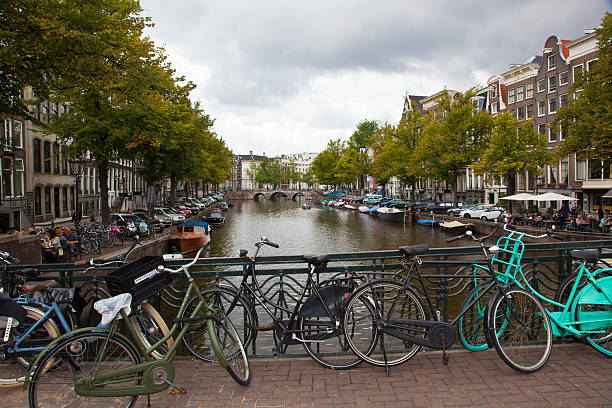 Bicicletas por um Canal em Amsterdã - foto de acervo