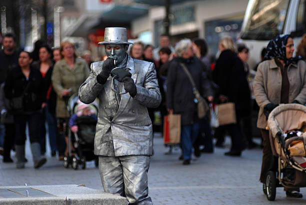 Liverpool, England - March 14, 2009: Street artist smoking and checking make-up with a mirror before performing
