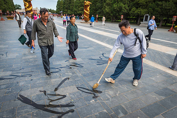hombre de pekín pintura escritura china templo del cielo park china - graffiti paintings men walking fotografías e imágenes de stock