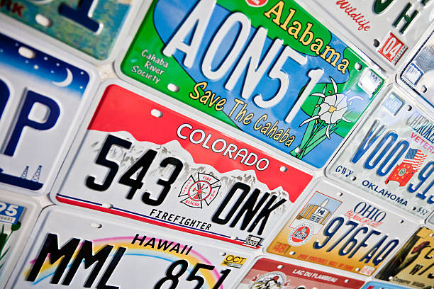 Colorado and Alabama License Plates New York City, New York - June 25, 2011: Close up of Colorado, Alabama and Hawaii license plates with other various states on the outside wall of a gas station new york state license plate stock pictures, royalty-free photos & images