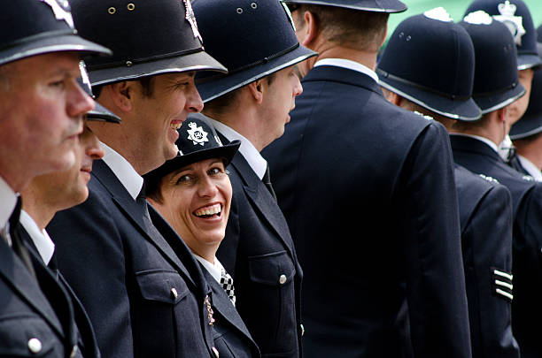 Line of police at the Royal Wedding, London London, United Kingdom - April 29, 2011: Royal Wedding. Female policewoman shares a joke with her male colleague as they line up on The Mall. The Metropolitan Police were involved in crowd control and safety during the Royal Wedding of Prince William and Kate Middleton. Thousands of people from around the world gathered in London to witness the spectacle. duchess photos stock pictures, royalty-free photos & images