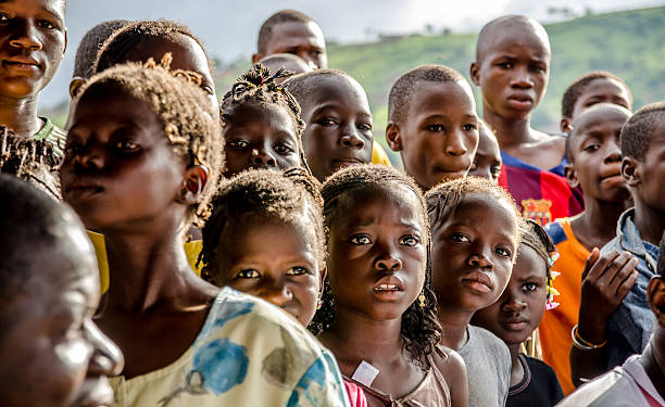 Group of worried young African children Bamako, Mali – August 17, 2013: A crowd of worried black children are staring at a soccer match in front of them in Bamako. Mali stock pictures, royalty-free photos & images