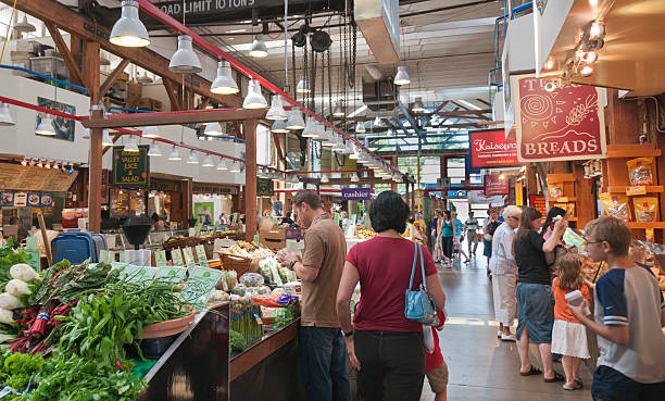 People shopping at Granville Market Vancouver, Canada - July 2, 2008: Tourists and locals alike visit Vancouver's busy public marketplace located on Granville Island which features a farmers market, day venders as well as artists. granville island stock pictures, royalty-free photos & images