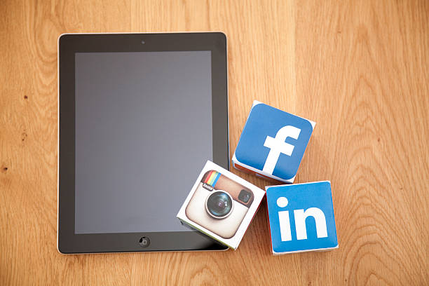 London, United KIngdom- September 24, 2013: Apple iPad alongside social media logos printed onto handmade cubes. Logos include Instagram, Facebook and Linkedin. Social media uses web and mobile technology to connect people
