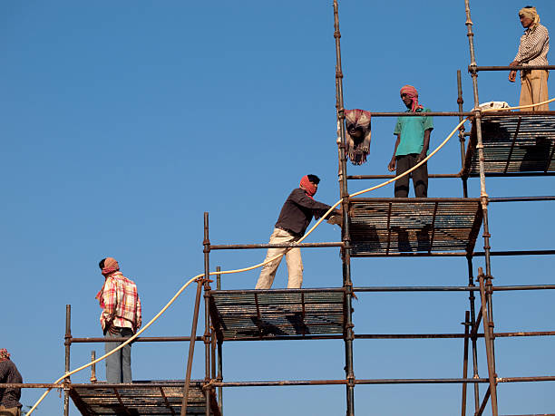 Section of a historic brick building with extensive scaffolding. The building appears to be undergoing restoration. Exterior construction work in progress, extensive modular metal scaffolding