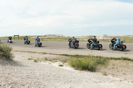 Badlands National Park, Soutth Dakota, USA - August 25, 2013: A group of men ride their Harley Davidson motorcycles in Badlands National Park in South Dakota, USA.