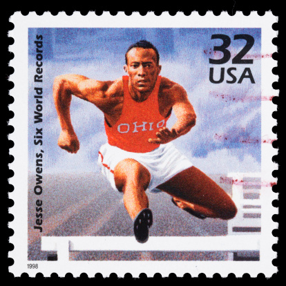 Sacramento, California, USA - March 20, 2011: A 1998 USA postage stamp with an illustration of Jesse Owens jumping over a track and field hurdle. On May 25, 1935 at the Big Ten Track and Field Championships, Owens set three world records and tied another in the span of less than one hour. The stamp design was done by Paul Calle.