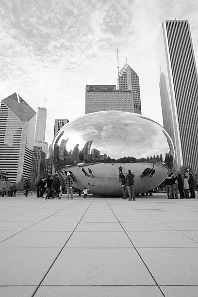 Spectators Around Cloud Gate In Chicago With Architecture Chicago, Illinois, USA - May 17, 2011: Within Millennium Park in Chicago, visitors gather in the open, public area around the Cloud Gate sculpture by Anish Kapoor.  Modern architecture, including the Aon Center at right, Prudential Plaza buildings at center, and Smurfit-Stone Building at left, forms the background. aon center chicago photos stock pictures, royalty-free photos & images