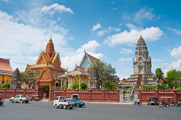 Phnom Penh, Cambodia - March 8, 2011: Traffic in front of the Royal Palace And Silver Pagoda In the river front area of Phnom Penh, Cambodia. The river front in Phnom Penh is a fast developing tourist area with many hotels, restaurants, bars and new developments being built around the ancient Palace and Temple