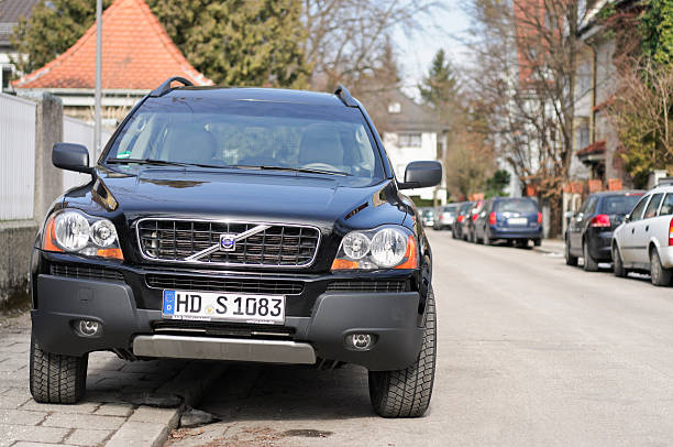 Munich, Germany - February 25, 2011: Front view of a Volvo XC90 four wheel drive Sports Utility Vehicle (SUV) parked on a residential city street, straddling the pavement and road.  The XC90 is one of the top selling models produced by Volvo.