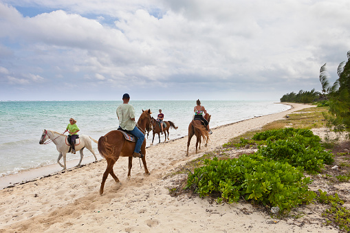 West Bay, Grand Cayman, Cayman Islands  - November 27, 2009: Two groups of people riding along the beach in Barkers National Park, the first national park ever created in the Caymans.