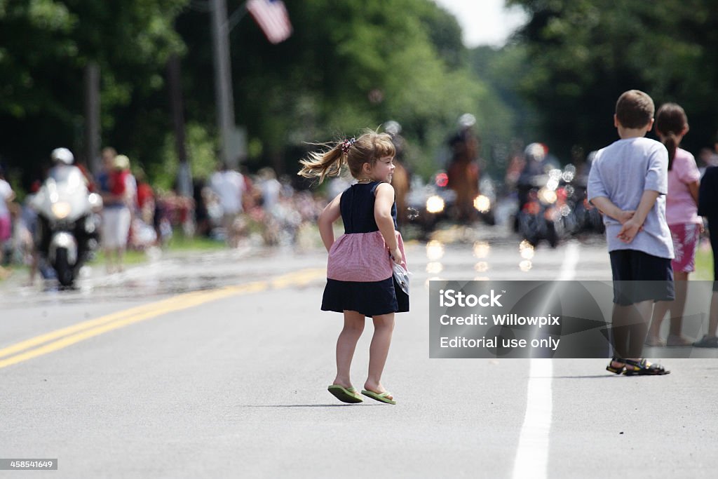 Молодая девушка Прыжки на радость на 4 июля Парад - Стоковые фото Парад роялти-фри