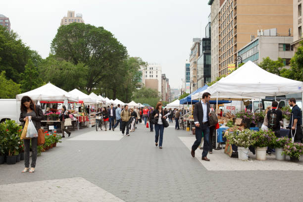 Union Square Greenmarket Farmers Market New York City New York, New York, USA - May 20, 2011: Union Square Greenmarket Farmers Market. This farmers market located in Union Square Park just above 14th street in New York City has been in existence since 1976. Customers can be seen perusing the many stands selling all types of fruits, vegetables, meats, fish, flowers, breads and more. union square new york city stock pictures, royalty-free photos & images