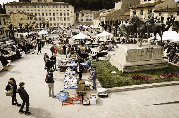 Fiesole, Italy - April 7, 2013: typical flea market in the main square of Fiesole, Florence, Italy. People is between the market stalls, looking for any occasion.