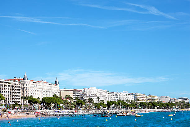 Cannes beach and Carlton International Hotel A!annes, France - September 18, 2013: View from the sea of the busy crowded beach and croisette boulevard in Cannes, Cote d'Azur, France with the facade and dome of the famous Carlton International Hotel and various other hotels.  The Carlton Hotel is used extensively by movie stars during the annual Cannes International Film Festival. cannes film festival stock pictures, royalty-free photos & images