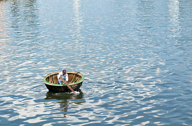 Fisherman is fishing on Quan Tuong river with many dried nipa palm - Nha Trang city, Khanh Hoa province, central Vietnam