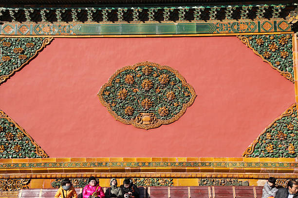 Beijing, China - December 22, 2011: Visitors warming up in the sun at the Forbidden City