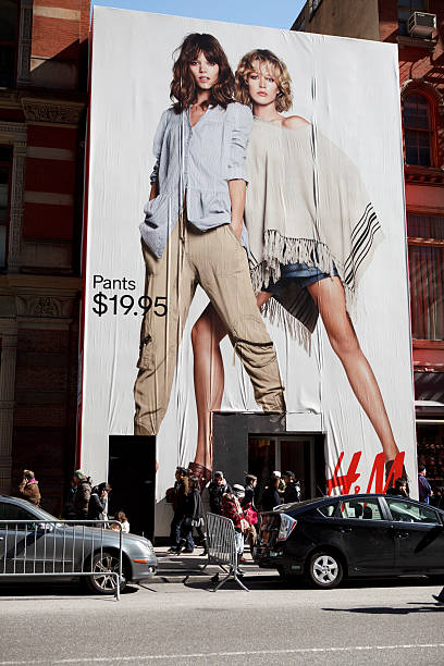 H & M Store Soho Manhattan New York, New York, USA - March 27, 2011: The H and M store on Broadway in the Soho area of downtown Manhattan. The store has a giant H and M billboard on the outside. People are seen going in and out of the store in the late afternoon. soho billboard stock pictures, royalty-free photos & images