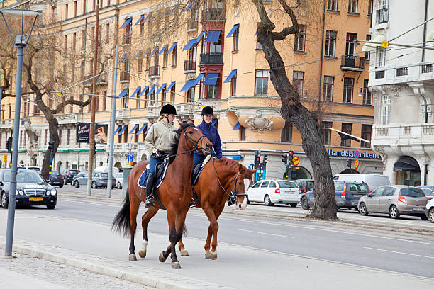 Stockholm- April 12, 2011: Two young women riding on Strandv&auml;gen,  central Stockholm with cars passing close by. To the riders right there is a quay with anchored old boats. Strandv&auml;gen leads ou to Djurg&aring;rden where riding without so much traffic is possible.