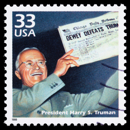 Sacramento, California, USA - March 20, 2011: A 1999 USA postage stamp with an illustration of Harry S. Truman (1884-1972), shortly after winning re-election in 1948, holding a Chicago Daily Tribune newspaper with the famously incorrect headline DEWEY DEFEATS TRUMAN. Truman served as the 33rd President of the US from 1945-1953, becoming President when FDR died early in his fourth term in 1945.