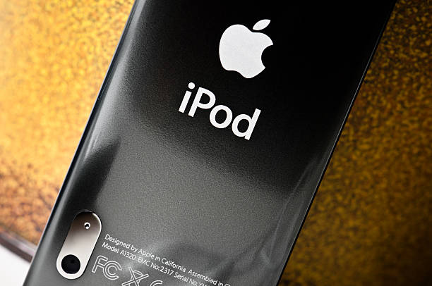 Udine, Italy - April 12, 2011: Studio shot showing Apple logo printed on the back metal case of an iPod Nano MP3 player. Orange background