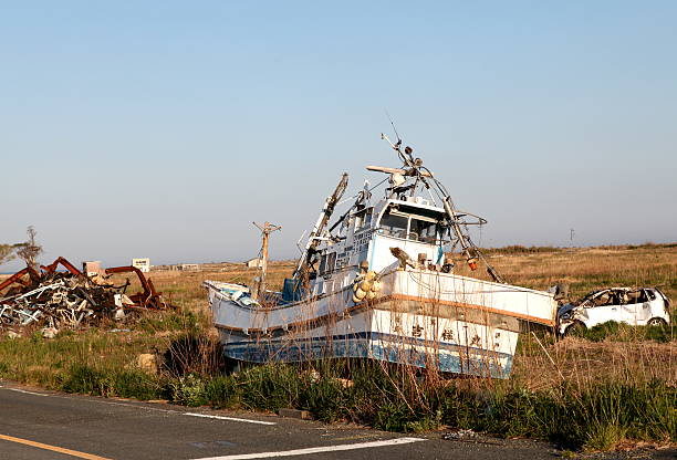 Fukushima, Japan, May 23, 2013: Boats sweept up on land by the 3.11 2011 tsunami that hit Japan. Two years after the earthquake this are close to the powerplant is still not cleaned up.