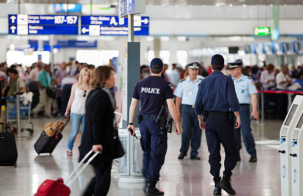 Os agentes de polícia em permanência no Aeroporto Internacional de Atenas, Grécia. - fotografia de stock